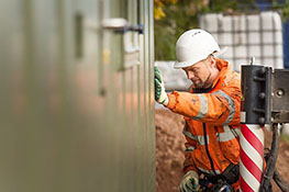Man wearing hi vis jacket setting a container building in place