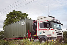 Side view of a container building unit on a lorry