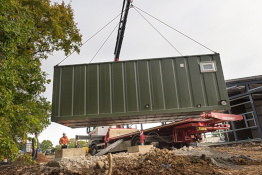 Container home unit being moved by a crane