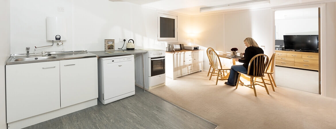 Woman sitting at a table in a container home kitchen-dining room