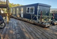 View of front of container houseboat and surrounding decking