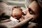 Man asleep with a sleeping baby on his chest