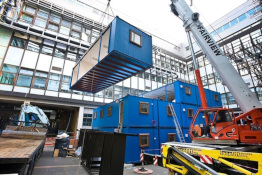 Container building being built with a crane