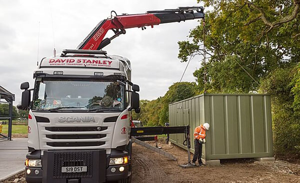 Container home being moved into position by a crane